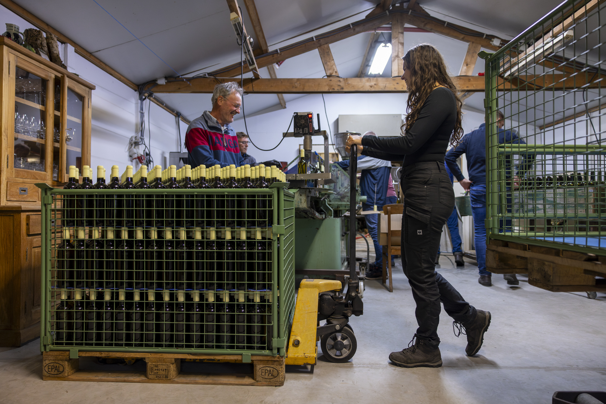 Chantal rijd een pallet vol wijnflessen op zijn plaats